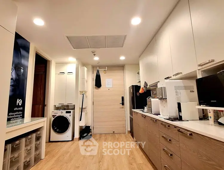 Modern kitchen with sleek cabinetry and built-in appliances in cozy apartment.