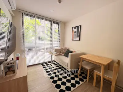 Cozy living room with modern decor, large windows, and stylish furniture in a bright apartment.