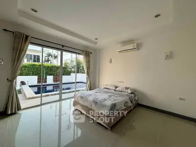 Spacious bedroom with pool view and modern decor in luxury home