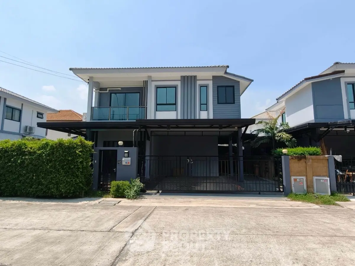 Modern two-story house with sleek design and spacious driveway in a suburban neighborhood.