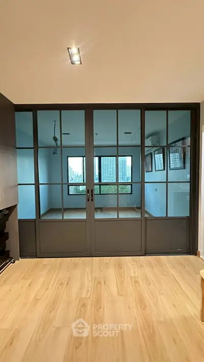 Modern interior with glass sliding doors and wooden flooring, showcasing a spacious and stylish living area.