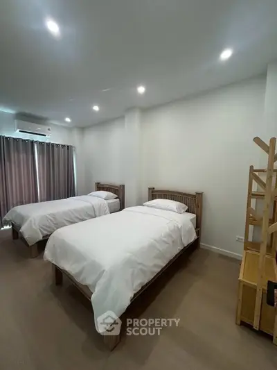 Spacious bedroom with twin beds and modern decor in a cozy apartment.