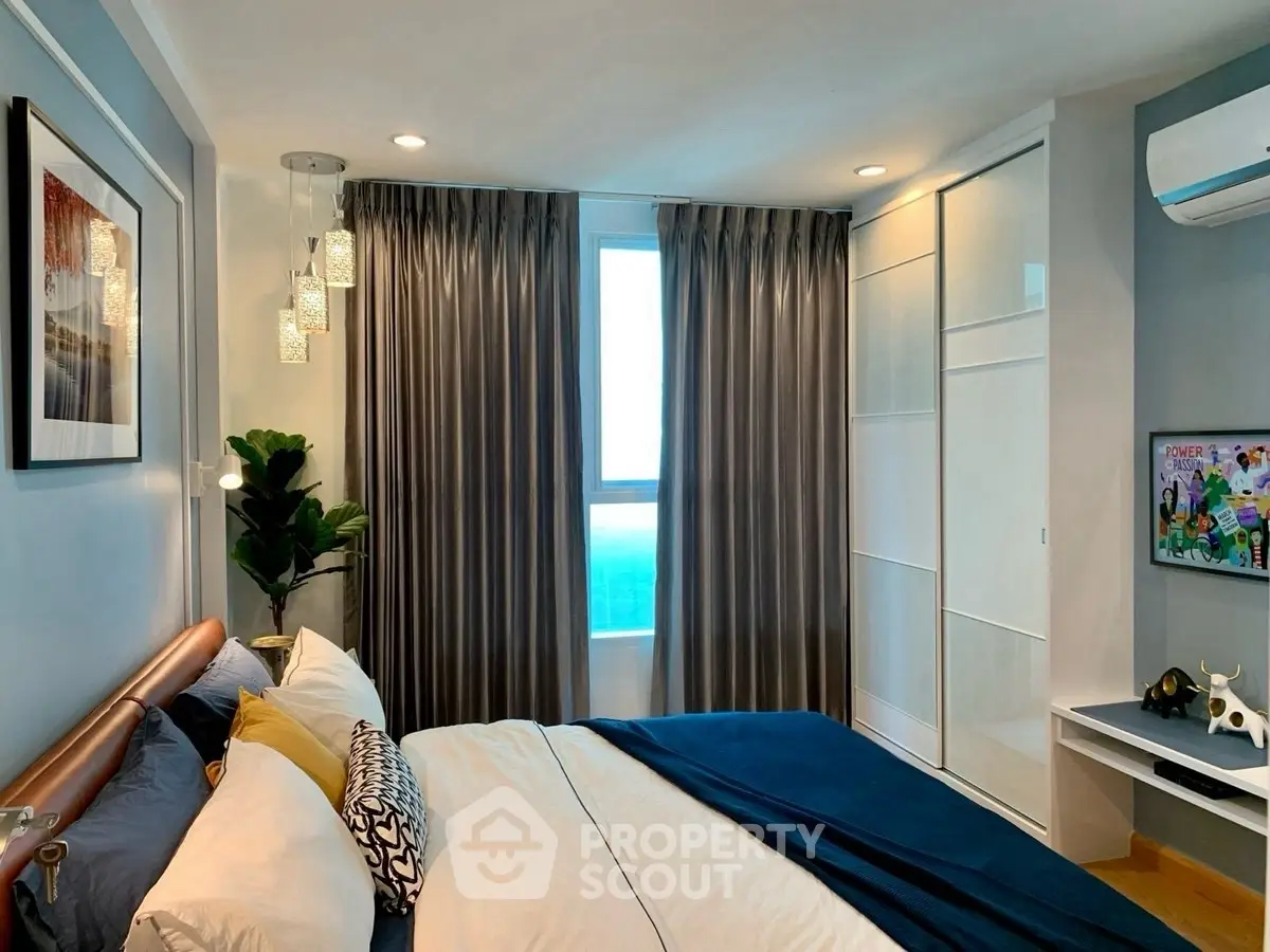 Modern bedroom with stylish decor, large window, and cozy ambiance in a contemporary apartment.