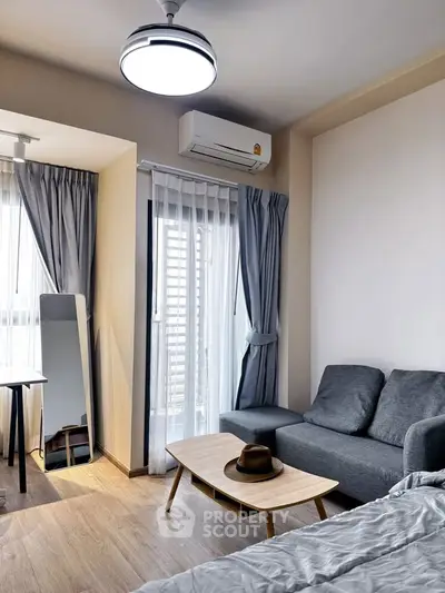 Modern bedroom with cozy seating area and natural light