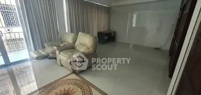 Spacious living room with plush recliner and elegant floor tiles, perfect for relaxation.