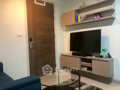 Cozy living room with modern decor, flat-screen TV, and stylish shelving.