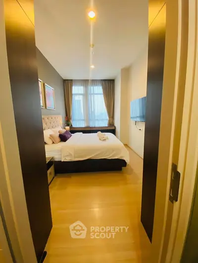 Luxurious bedroom with modern decor and large window offering natural light.