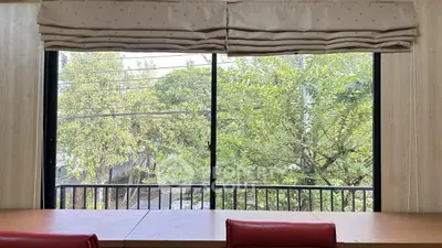 Bright study room with large window overlooking lush green trees