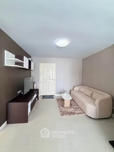 Spacious living room with modern furniture and neutral tones, perfect for relaxation and entertainment.
