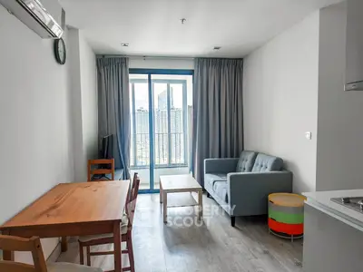 Modern living room with city view, featuring cozy seating and dining area, perfect for urban living.