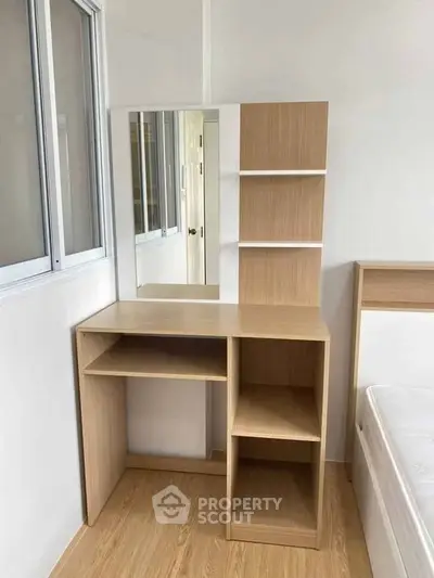 Modern bedroom with sleek wooden furniture and built-in shelves, perfect for minimalist living.