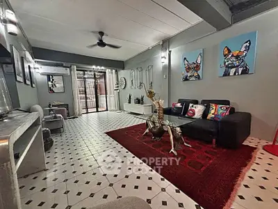 Stylish living room with modern decor and vibrant artwork, featuring a cozy seating area and elegant lighting.