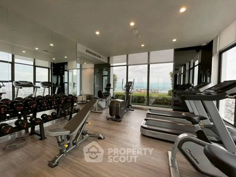 Modern gym with panoramic city views and state-of-the-art equipment.