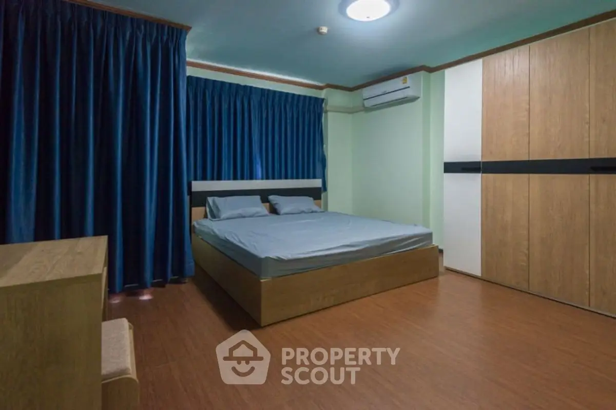 Spacious bedroom with modern furnishings and ample natural light.