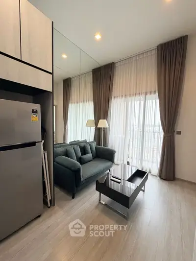 Modern living room with floor-to-ceiling windows and sleek furniture in a stylish apartment.