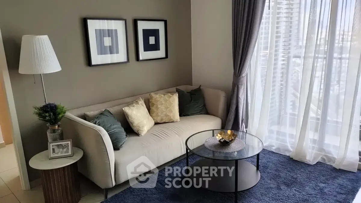 Chic modern living room with cozy sofa, elegant decor, and large window for natural light.