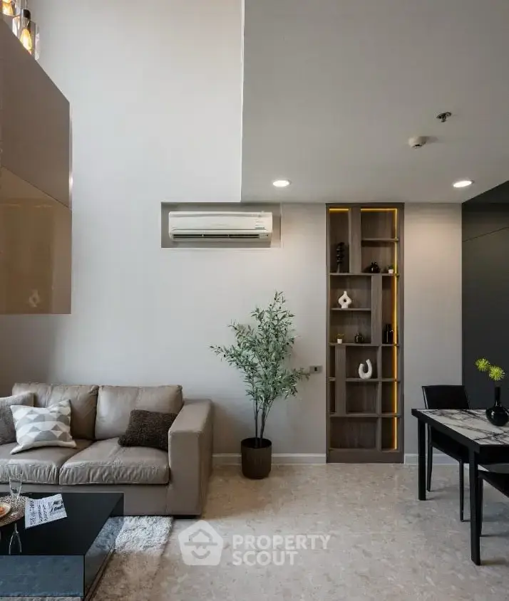 Modern living room with stylish decor and open layout, featuring a cozy sofa and elegant dining area.
