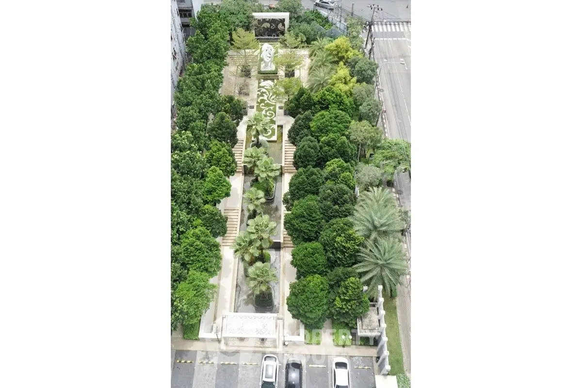 Stunning aerial view of lush garden with elegant pathways and statues, perfect for serene outdoor living.
