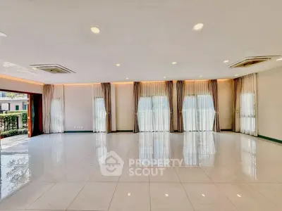 Spacious and elegant living room with large windows and modern lighting