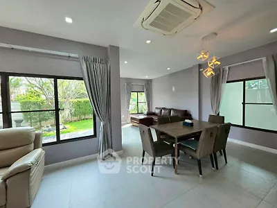 Spacious living room with garden view, modern furniture, and elegant lighting in a stylish home.