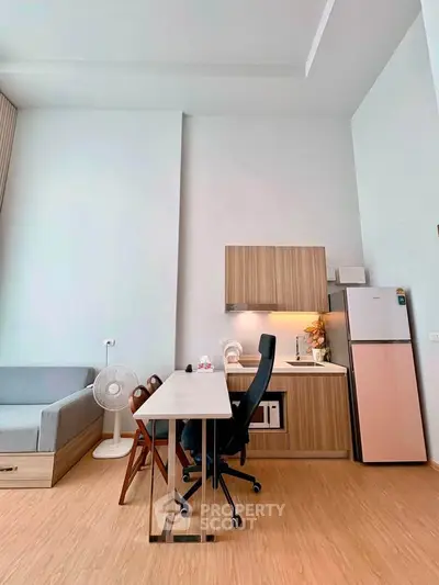 Modern studio apartment with compact kitchen and workspace, featuring sleek wooden cabinetry and minimalist design.