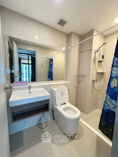 Modern bathroom with sleek fixtures and large mirror in a contemporary apartment.