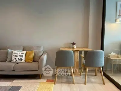 Cozy living room with modern sofa and dining set, perfect for relaxation and entertaining.