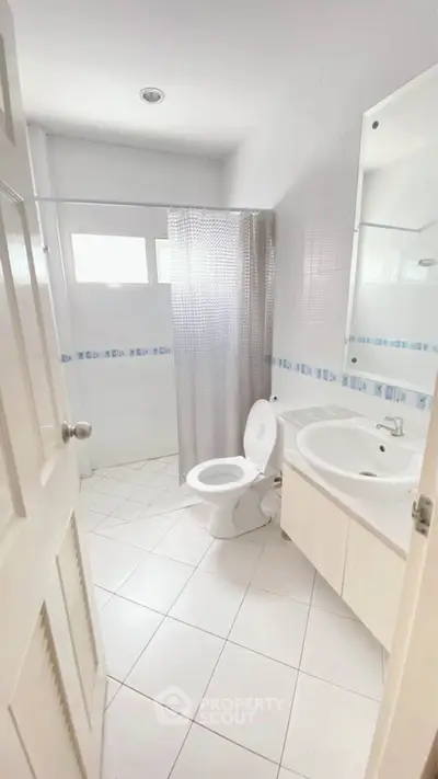 Bright and clean bathroom with modern fixtures and tiled flooring.
