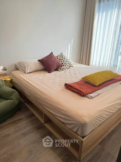 Cozy bedroom with natural light, featuring a stylish bed and modern decor, perfect for relaxation.