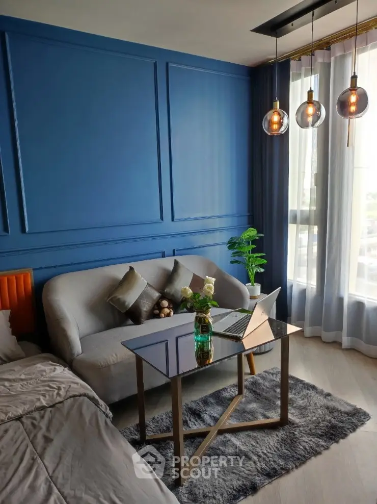 Stylish modern living room with blue accent wall and cozy seating area.