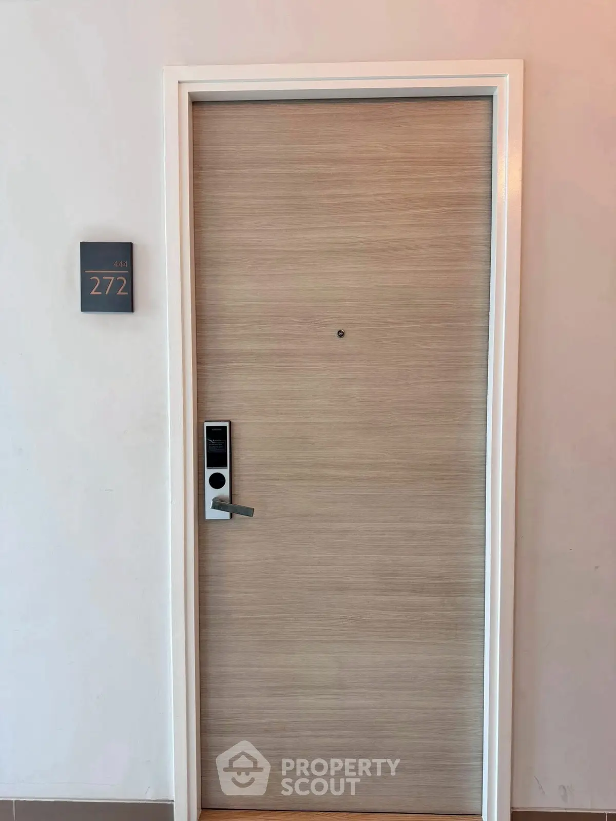 Modern apartment door with electronic lock and room number 272, showcasing secure entryway.
