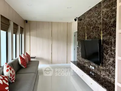 Modern living room with sleek TV unit and stylish sofa, featuring elegant decor and natural light.