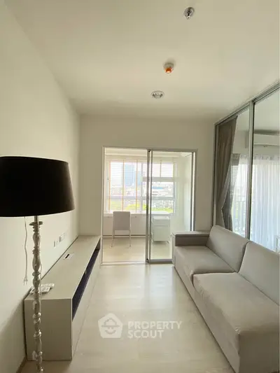 Modern living room with sleek furniture and large windows offering natural light and a view.