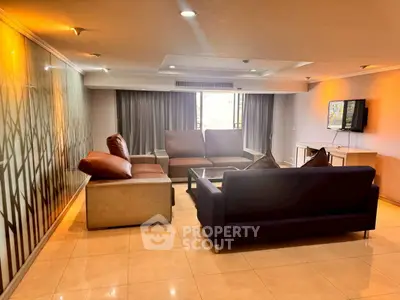 Spacious living room with modern furniture and large windows offering natural light.