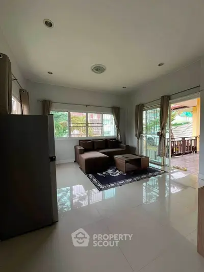 Spacious living room with modern furniture and large windows offering natural light.