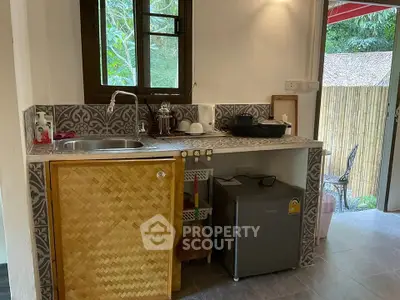 Charming rustic kitchen with bamboo cabinet and modern appliances in a cozy home setting.