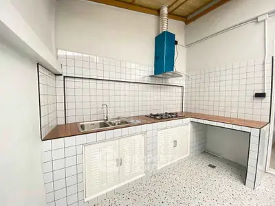 Charming kitchen with tiled walls and gas stove, perfect for culinary enthusiasts.