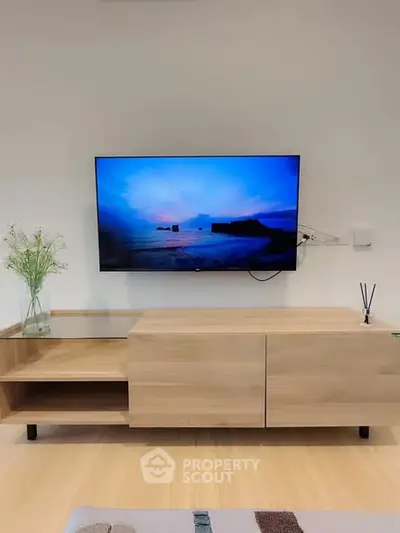 Modern living room with sleek wooden TV stand and mounted flat-screen TV.