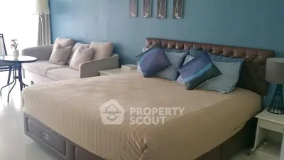 Spacious bedroom with elegant decor and cozy seating area, perfect for relaxation.