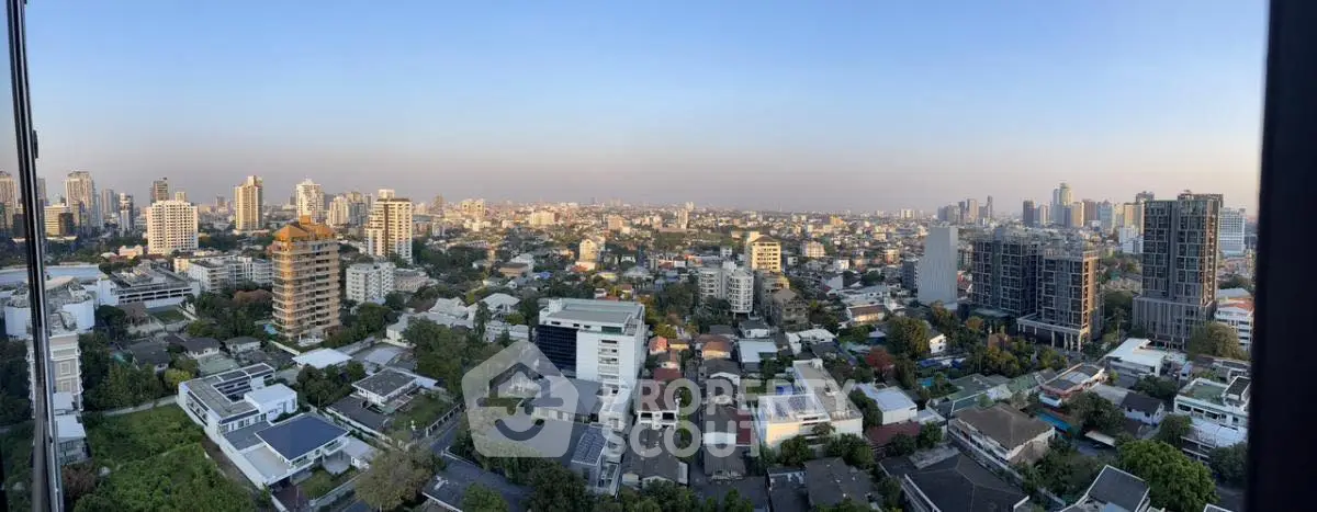 Panoramic cityscape view showcasing urban skyline and residential buildings at sunset.