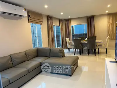 Spacious modern living room with elegant dining area and cozy sectional sofa.