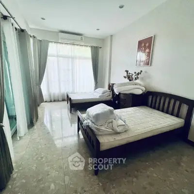 Spacious bedroom with twin beds and large windows for natural light