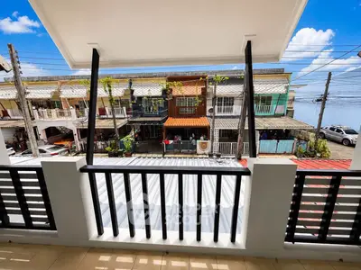 Charming balcony view overlooking vibrant neighborhood with clear blue skies.