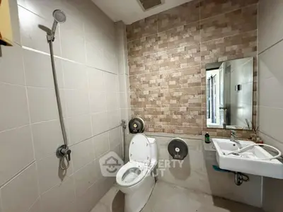 Modern bathroom with sleek fixtures and tiled walls in a contemporary apartment.
