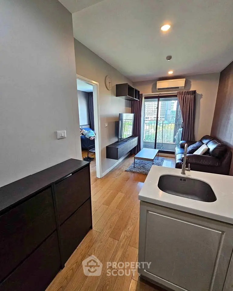 Modern living room with sleek furniture and city view, featuring open layout and stylish decor.