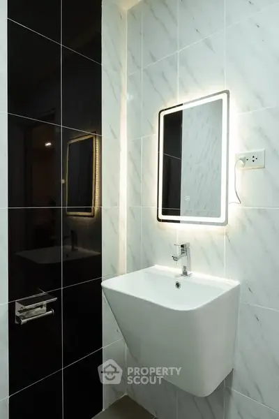 Modern bathroom with sleek sink and illuminated mirror