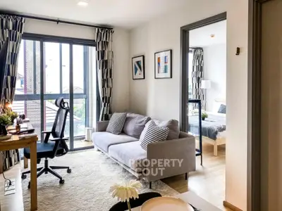 Modern living room with cozy sofa and study area in bright apartment