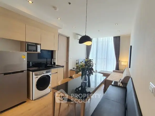 Modern open-plan kitchen and living room with sleek appliances and stylish decor.