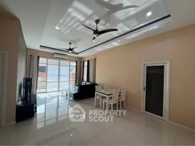 Spacious modern living room with elegant ceiling fans and natural light, perfect for family gatherings.