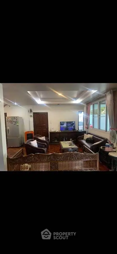 Spacious living room with elegant furniture and natural light, perfect for family gatherings.